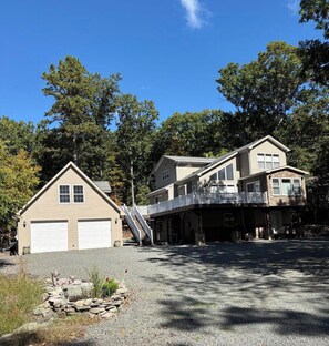 A two-story house with a garage, a covered porch, and a stone wall with a statue. - Masthope  PA vacation retreat / Ski•Lake•Pool
come enjoy with family and friends (Lackawaxen)