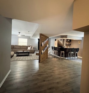 A modern living room with a sofa, coffee table, and a wooden accent wall. - Masthope  PA vacation retreat / Ski•Lake•Pool
come enjoy with family and friends (Lackawaxen)