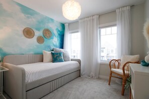 A bedroom with a bed, a desk, a chair, a window, and a wall with a painted sky mural. - Harmony House | Cozy 4-Bedroom Niagara Retreat · EV Charger · Sleeps 8 (Welland)