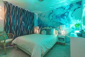 A bedroom with a bed, nightstands, a chair, and a wall mural. - Harmony House | Cozy 4-Bedroom Niagara Retreat · EV Charger · Sleeps 8 (Welland)