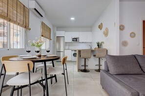 Une cuisine moderne avec un coin repas, un canapé et des œuvres d’art décoratives au mur.