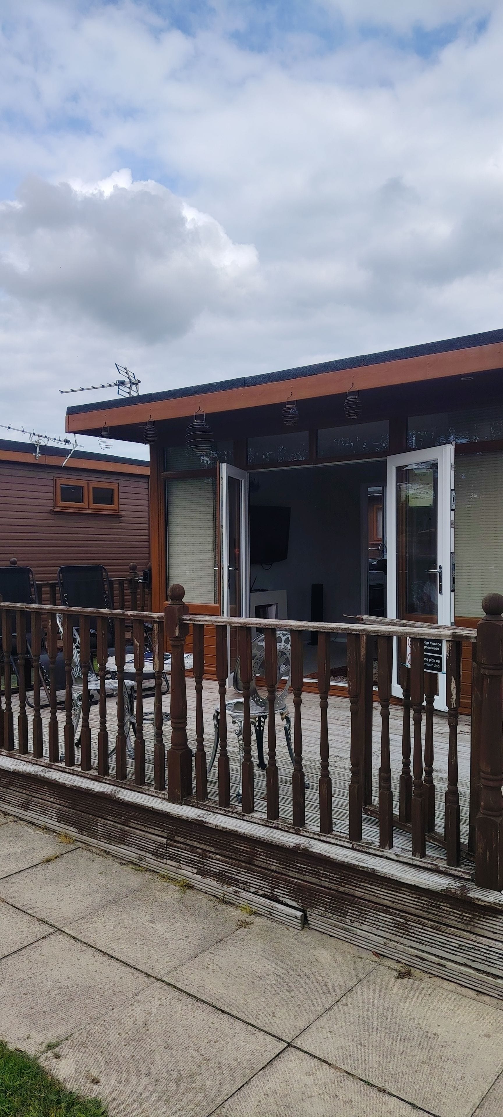 A wooden building with a metal fence in front.