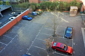 A parking area with multiple cars and a tree. - Luxury 2-Bed 2-Baths City Centre Apartment |  FREE Secure Parking, Balcony (Birmingham)