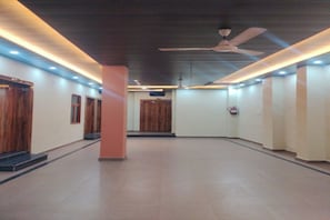 Un pasillo con puertas de madera, un ventilador de techo e iluminación empotrada.