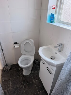 Un baño con inodoro, lavabo y ventana.