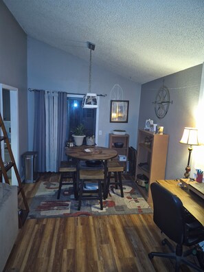 A dining area with a wooden table, chairs, and a hanging light fixture. - Serene 1-bedroom house with AC in Tulsa perfect for relaxing (Tulsa)