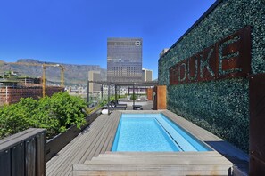 A rooftop pool with a view of a cityscape, including a building with 'Duke' on its facade. - Stylish 1Bed at The Duke with Rooftop Pool & Views in Cape Town (Cape Town)
