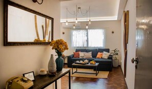 A living room with a sofa, coffee table, and a vase of flowers. - Comfortable and cozy apartment in a great location (Mendoza)