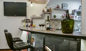 A kitchen with a bar area, a television, and various kitchen items. - Comfortable and cozy apartment in a great location (Mendoza)