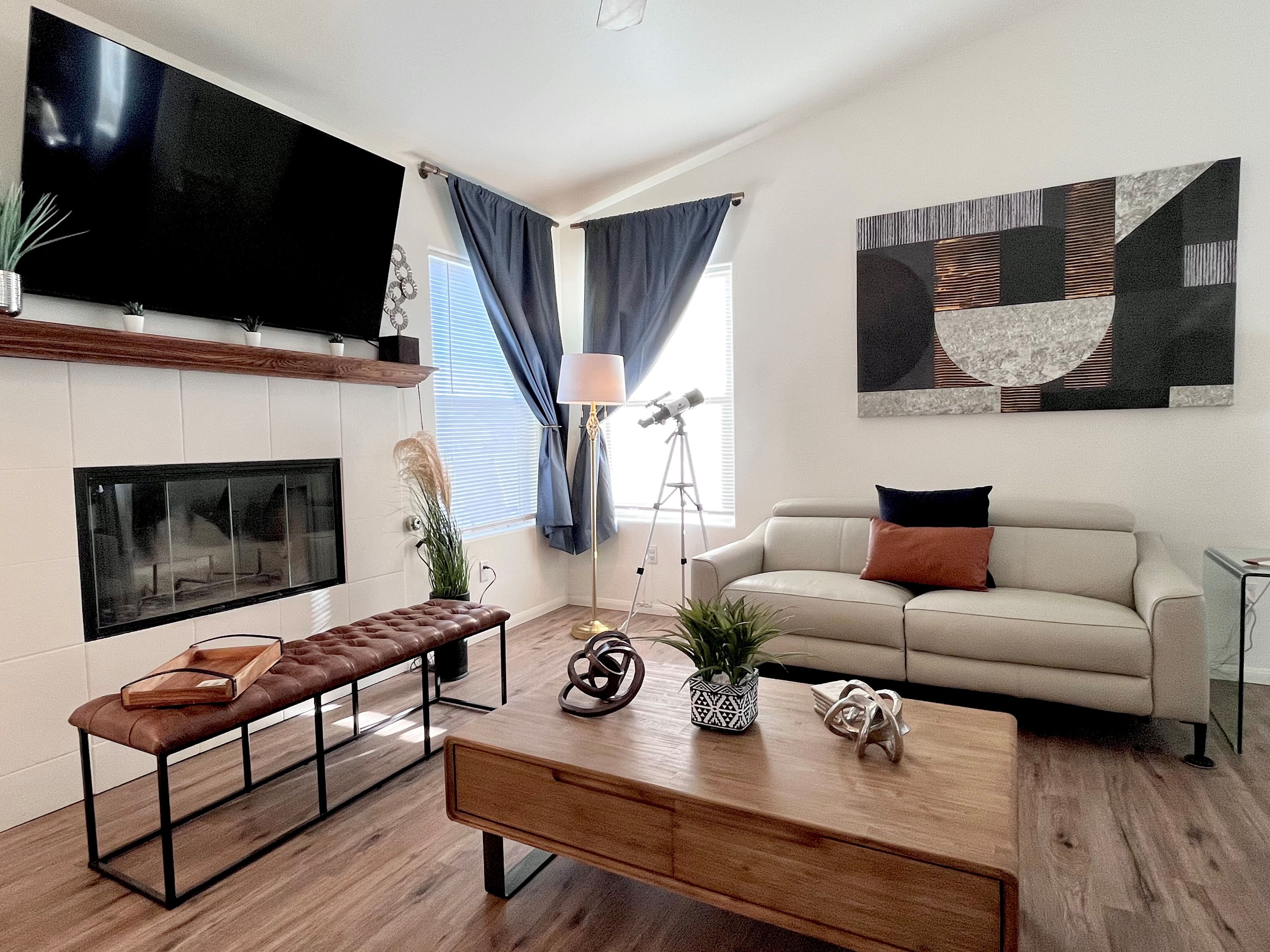 A modern living room with a flat-screen TV, a sofa, a coffee table, and a bench.