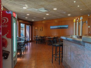 A restaurant interior with a counter, seating area, and a vending machine.