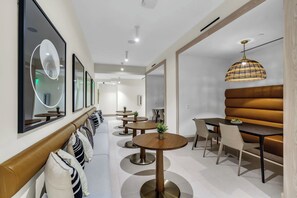 Ein modernes Interieur mit einer Sitzecke, Esstischen und einer besonderen Pendelleuchte.