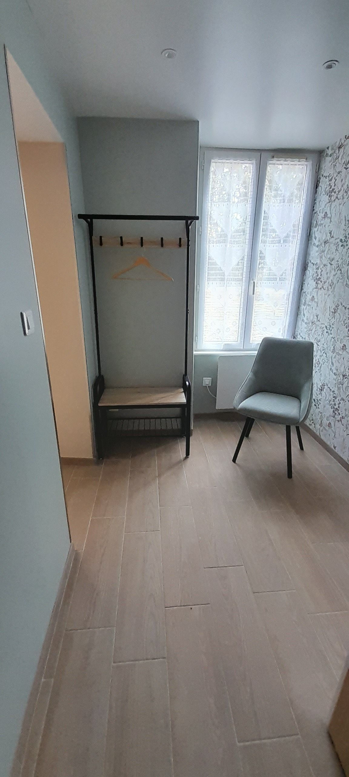 Una habitación con una cama, una silla y una ventana.