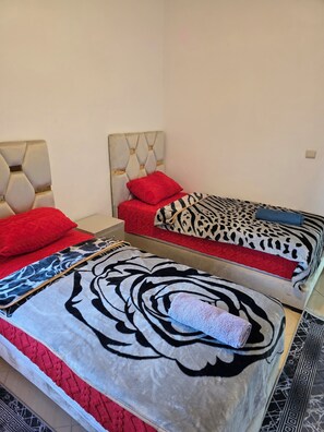 A room with two beds, each with distinct patterned bedding. - Lady Plaza Apartment (Marrakech)