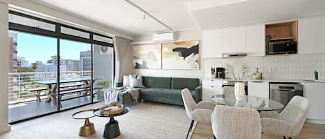 A modern apartment with a balcony, a dining area, and a kitchen.