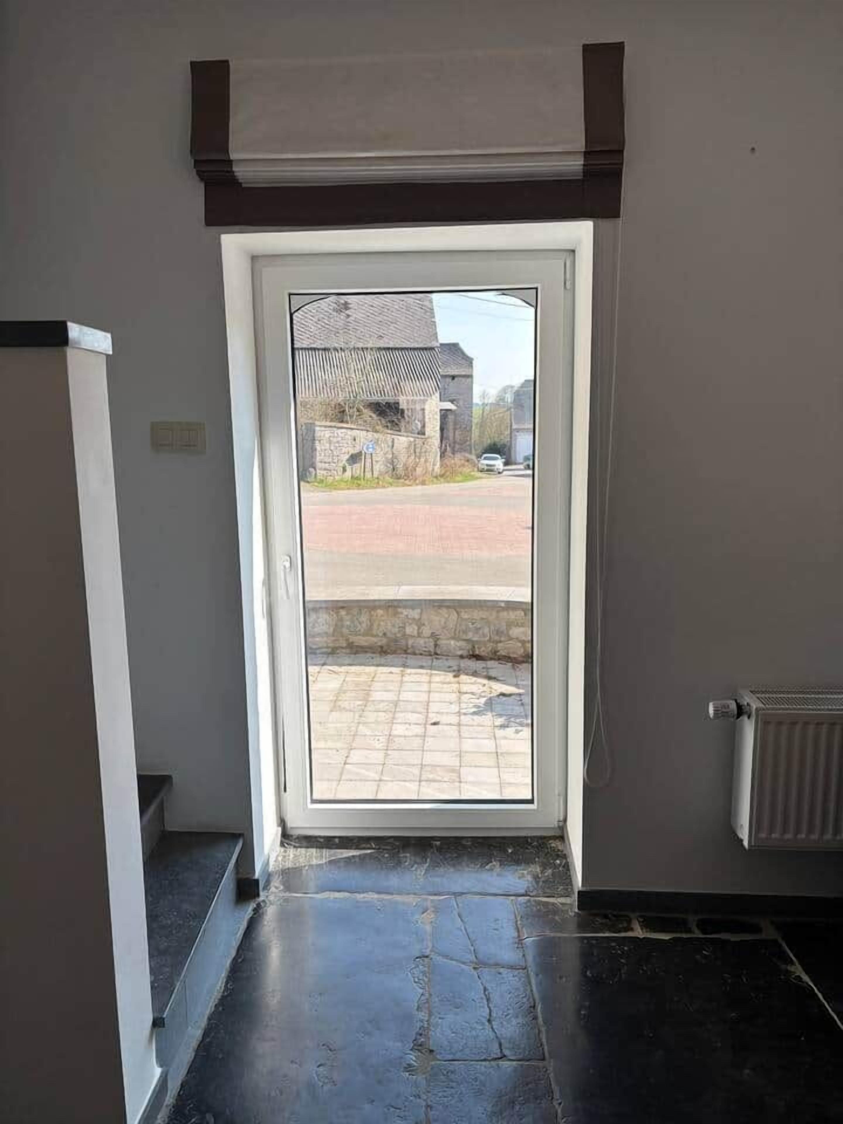 Una entrada que da a un espacio exterior con vista a una calle y edificios.