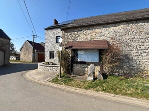 Ein Steinhaus mit einem sichtbaren Eingang und einem Schild.