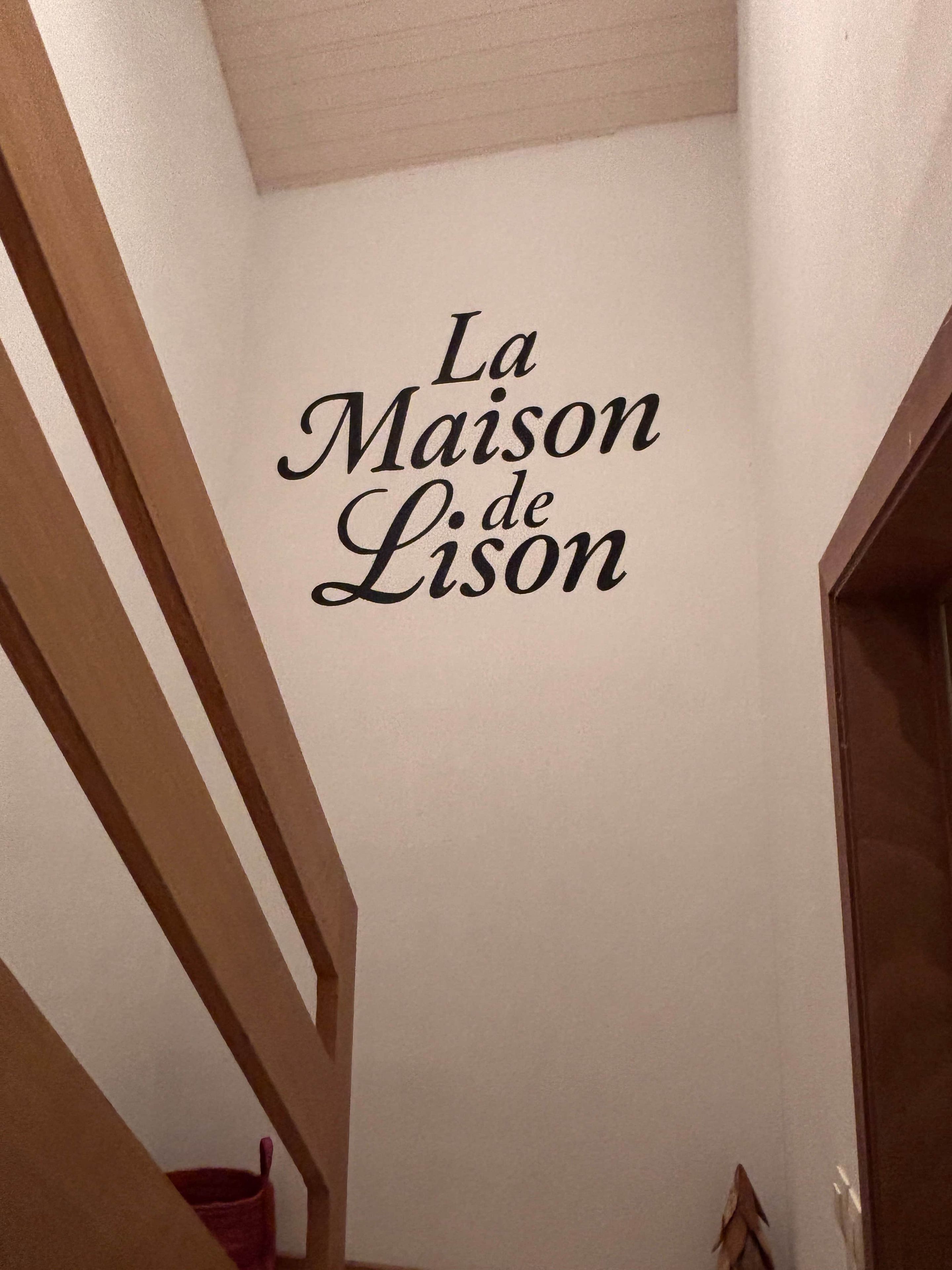 Een trap met een bord dat 'La Maison de Lison' vermeldt.