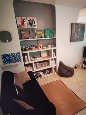 A living room with a sofa, a bookshelf, and a bean bag chair. - A quiet house near Avignon and Saint-Rémy-de-Provence, with a view of the Alpilles (Châteaurenard)
