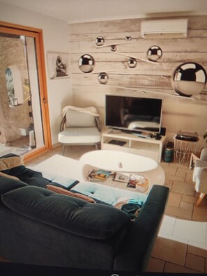 A living room with a sofa, a coffee table, a television, and a decorative mirror on the wall. - A quiet house near Avignon and Saint-Rémy-de-Provence, with a view of the Alpilles (Châteaurenard)