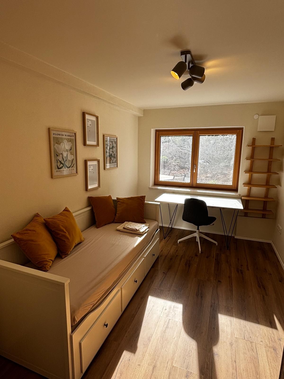 A compact room with a bed, a desk, and a window.