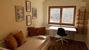 A compact room with a bed, a desk, and a window.