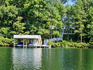A dock with a covered seating area and a house in the background. - ⛵ The Social House | Lake Gaston Waterfront, Dock, Porches, Arcade & Ping-Pong ☀ (Henrico)