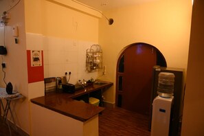 A kitchen with a wooden countertop, a water dispenser, and a sink.
