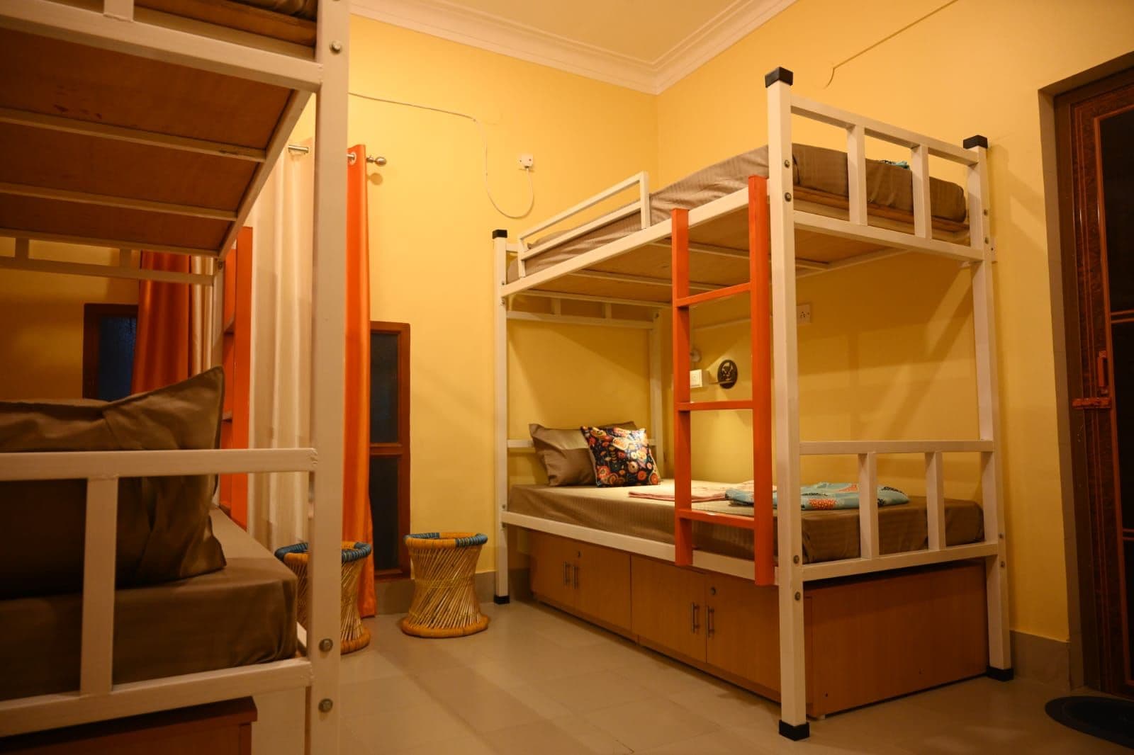 A room with bunk beds, a small table, and a chair.