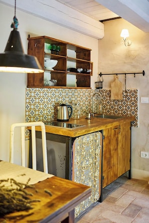 A kitchen with a wooden counter, a sink, and a hanging light fixture. - Apartment in a stone mill with panoramic view (Mombaroccio)