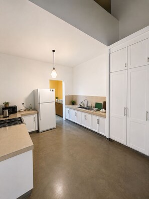 A modern kitchen with white cabinetry, a built-in oven, and a central island with a stove. - Private Designer 3BR Villa in Battaramulla | Sleeps 7 | Near Colombo (Battaramulla)