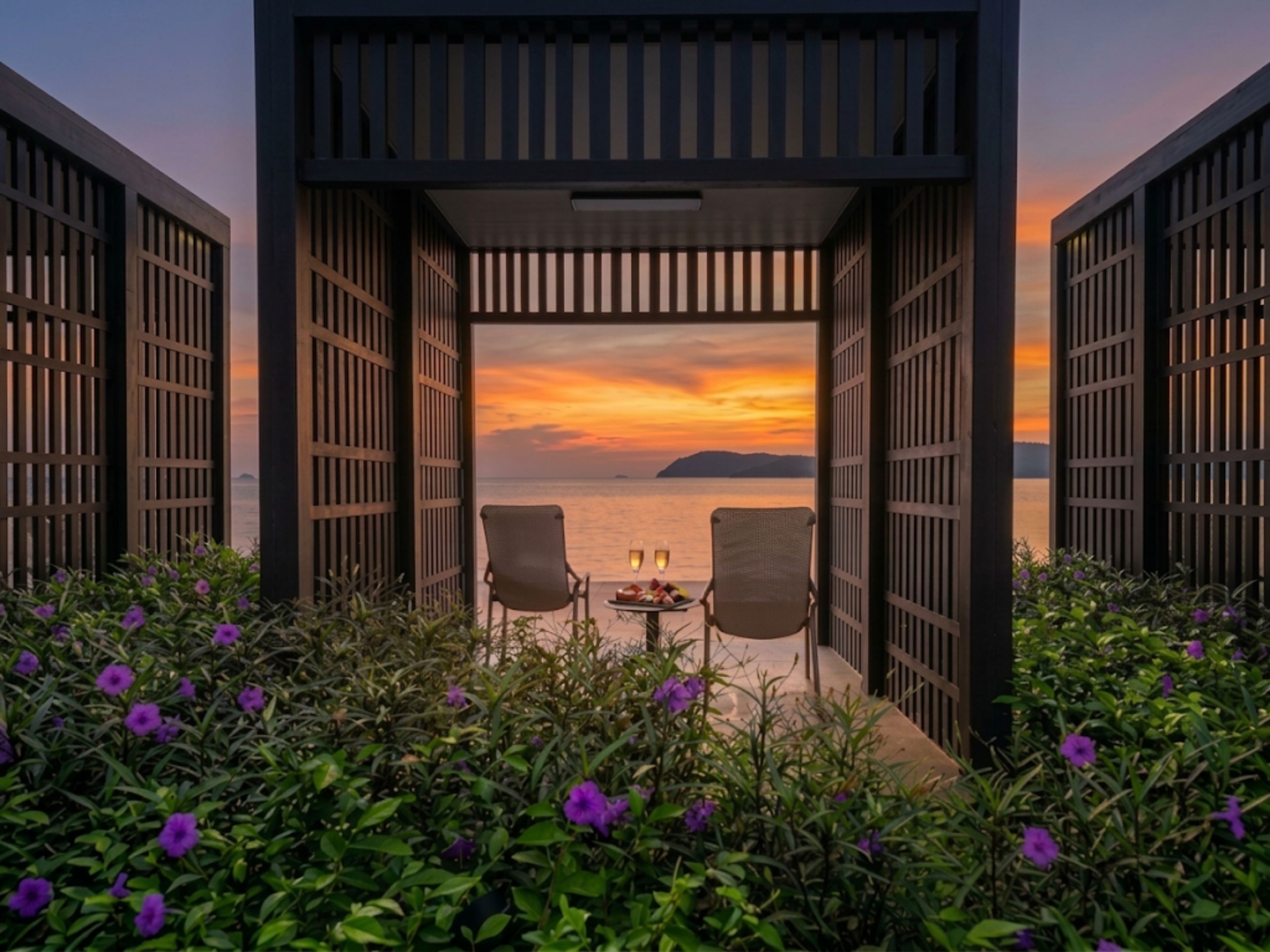 Een open constructie met twee stoelen gericht op een uitzicht op het water tijdens zonsondergang.