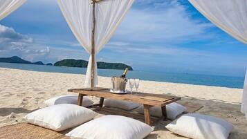 Private beachfront cabana dining with ocean views and island scenery