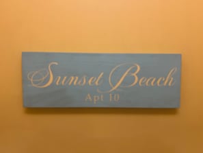 A sign with the text 'Sunset Beach Apt 10' on a blue background. - Sunset Beach Unit 10 St Lawrence Gap Condos (Oistins)