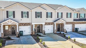 Filera de cases adossades amb garatges integrats, façanes de maó i petits jardins davanters.