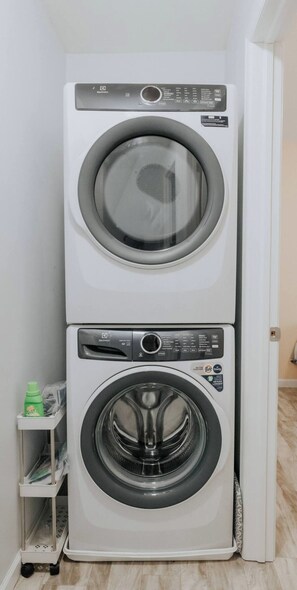Una lavadora y secadora apiladas en un cuarto de lavandería.
