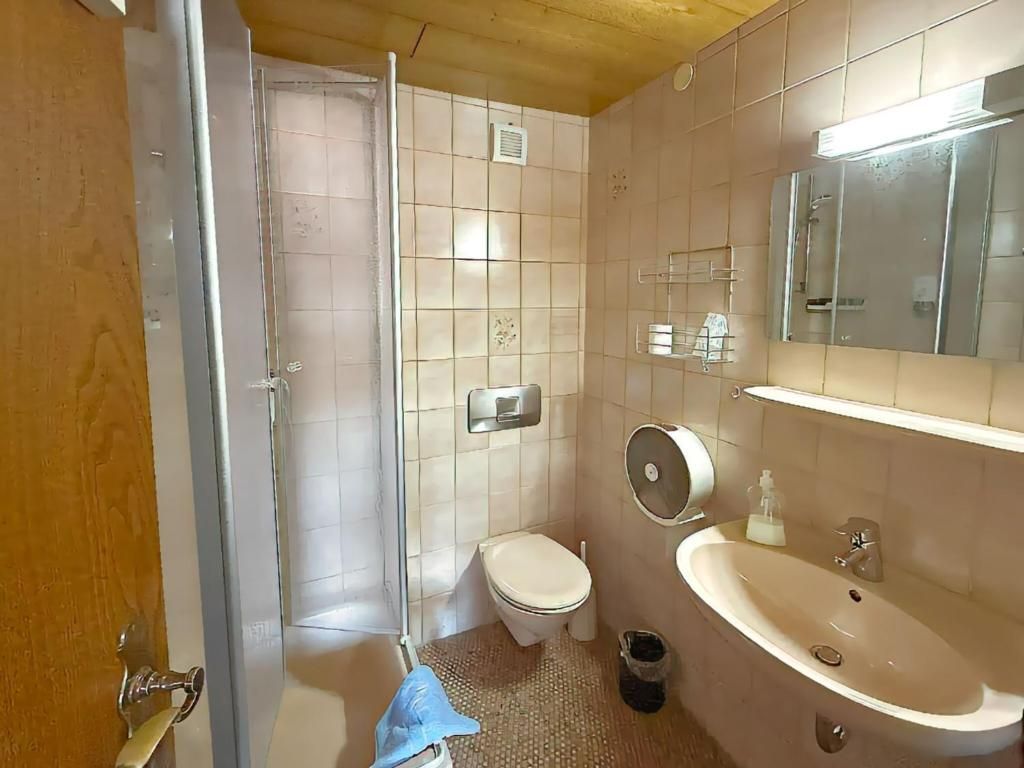 Un baño con inodoro, lavabo y ducha.