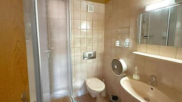 Un baño con inodoro, lavabo y ducha.