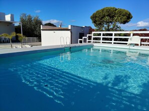 A clear swimming pool with a white deck and a white fence. - Villa Anemone: Relax by the Pool and the Sea (Sicilia)