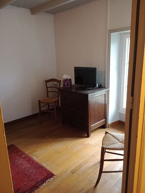 A room with a wooden desk, a chair, a television, and a red rug. - Charm and tranquility near Futuroscope and Chauvigny (Bonnes)