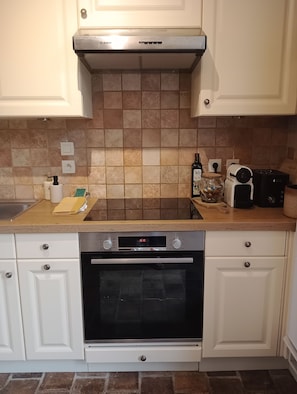 A kitchen with white cabinets, a Bosch oven, a toaster, and a bottle of beer on the counter. - Charm and tranquility near Futuroscope and Chauvigny (Bonnes)