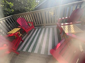 A deck with a striped floor mat, red chairs, and a yellow table. - Lovely 2 bdrm Semi-detached (Calgary)