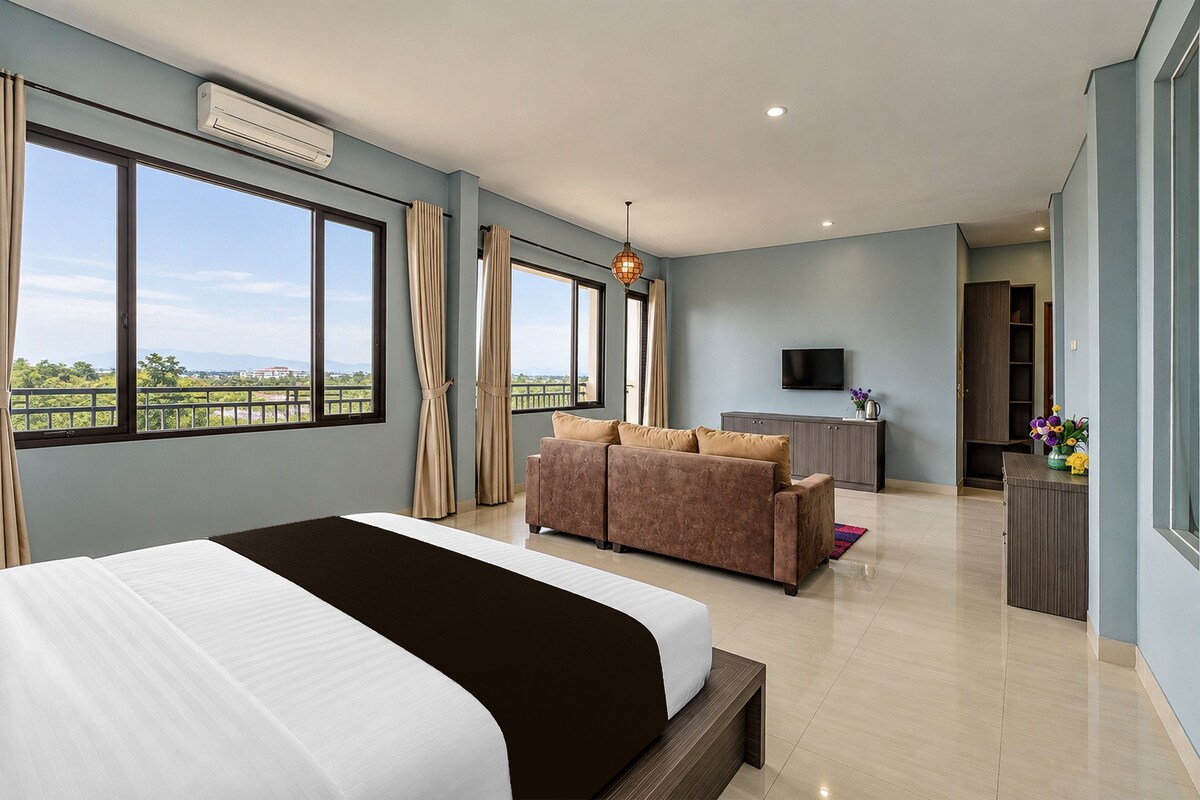 Una habitación de hotel moderna con una cama grande, un sofá, un escritorio y una televisión.