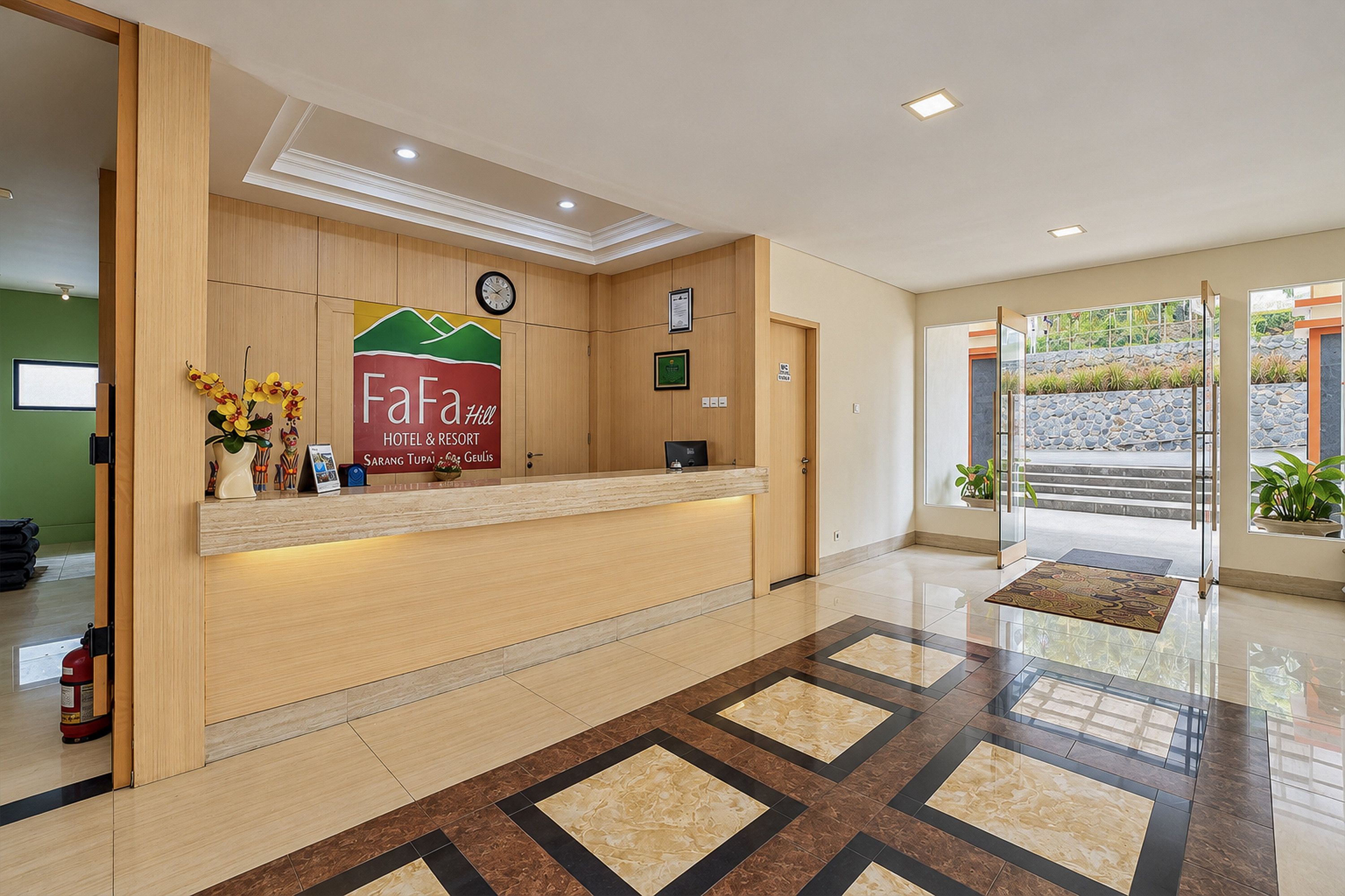 Un espace d’accueil d’hôtel avec un comptoir de réception en bois, une horloge et un panneau indiquant le nom de l’établissement : FaFa Hill Hotel & Resort.