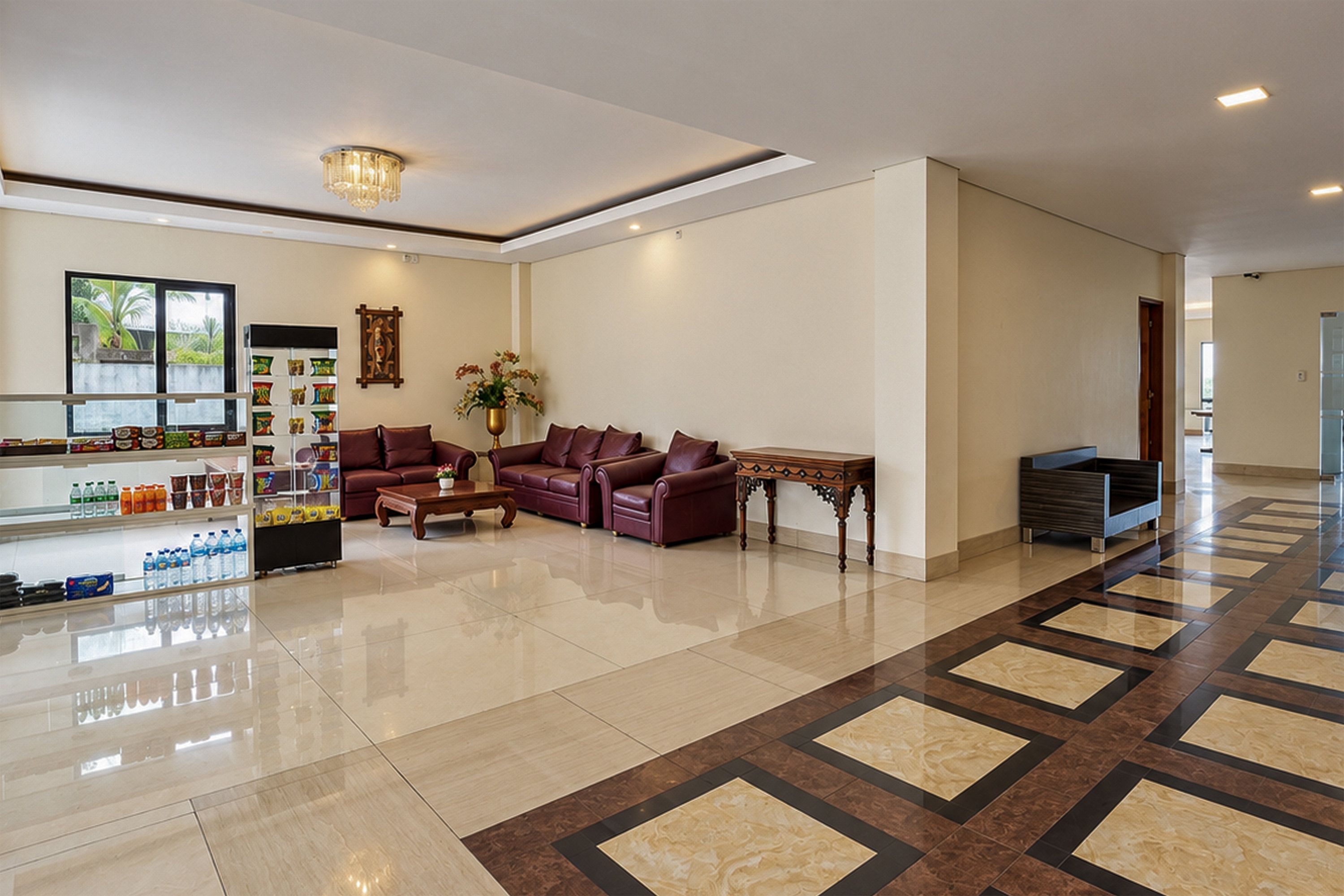 A hotel lobby with a reception desk, seating area, and a decorative wall.