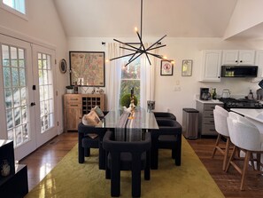 Una cocina moderna con una mesa de comedor, sillas y una araña.