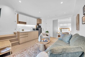 A modern apartment with a kitchen, dining area, and living room. - Brand New Cozy and Private Guest Suite in Mount Pleasant (Vancouver)