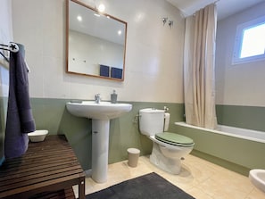 Une salle de bain avec un lavabo, des toilettes et une baignoire.