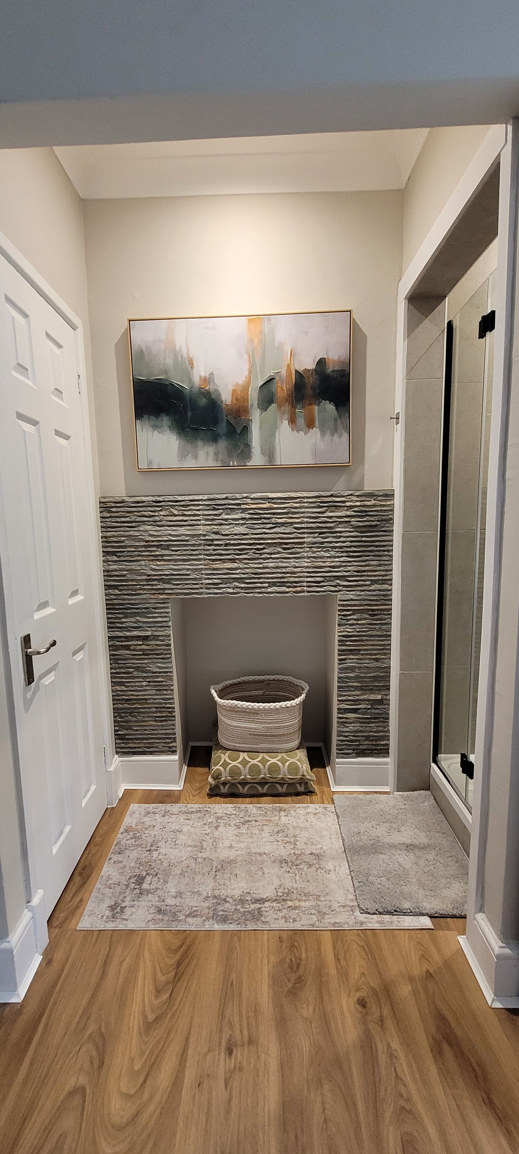 A room with a fireplace, a rug, and a door.