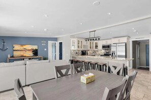 A modern kitchen with white cabinets, a built-in microwave, and a stainless steel refrigerator. - Pipe Dream - Waterfront + Pool + 120' Dock (Marathon)